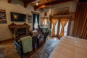 a bedroom with a bed and a desk and a fireplace at Santuario Grande in Los Ranchos de Albuquerque