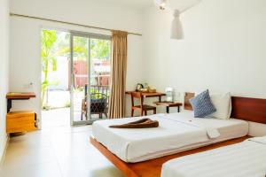 a bedroom with two beds and a sliding glass door at Onederz Koh Rong Sanloem in Koh Rong Sanloem