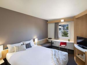 a hotel room with a bed and a television at ibis Newcastle in Newcastle +58 photos