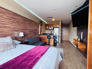 a hotel room with a large bed and a kitchen at Loft moderno y acogedor in Durango