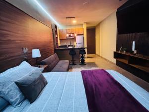 a bedroom with a large bed and a couch at Loft moderno y acogedor in Durango