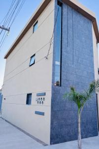 a blue and white building with a palm tree in front of it at Loft moderno y acogedor in Durango