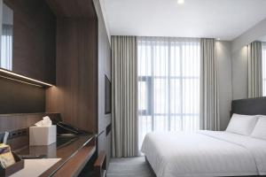 a hotel room with a bed and a desk at Amrise Hotel Kitchener in Singapore +83 photos