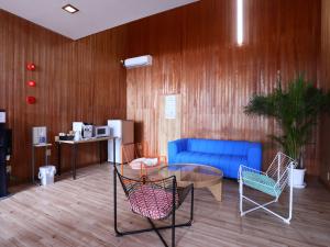 a lobby with a blue couch and a table and chairs at 旅館紀の国 in Kaino