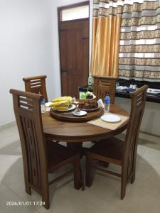 a wooden table with a plate of food and bananas on it at Misty Morning Villa Ella in Ella