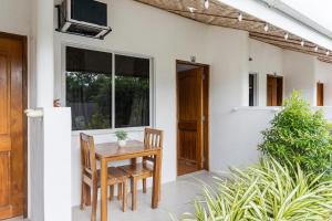 a patio with a table and chairs and a door at Badi's Place in Moalboal