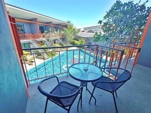 a table and two chairs on a balcony with a pool at Ohophuket in Phuket