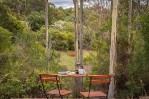 a table and two chairs on a porch at Wattle Grove Hideaway by Tiny Away in Wattle Grove +21 photos