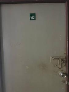 a white door with the number on it at room 102 in Wanna Apt in Pattaya