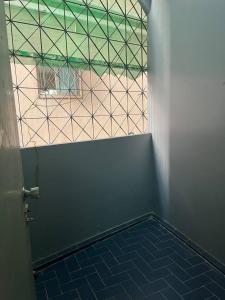 a room with a window and a blue tiled floor at room 102 in Wanna Apt in Pattaya