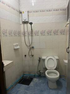 a bathroom with a toilet and a shower at room 102 in Wanna Apt in Pattaya