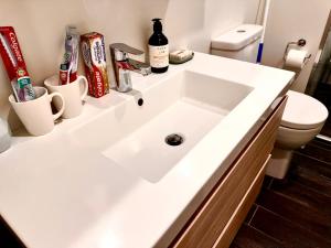 a bathroom with a white sink and a toilet at Connect 204 in Auckland +13 photos