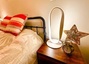 a lamp on a wooden table next to a bed at Connect 204 in Auckland