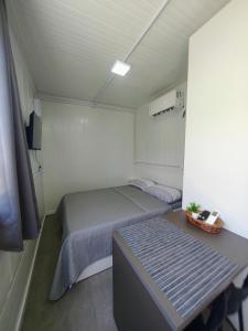 a small bedroom with two beds and a table at Loft Navegantes Próximo Aeroporto e BR 101 in Navegantes