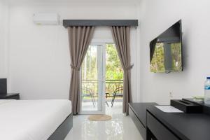 a hotel room with a bed and a balcony at Urbanview Hotel AnD Lampung by RedDoorz in Lampung