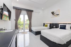 a bedroom with two beds and a balcony at Urbanview Hotel AnD Lampung by RedDoorz in Lampung