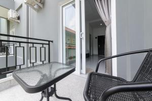 a balcony with a glass table and a chair at Urbanview Hotel AnD Lampung by RedDoorz in Lampung