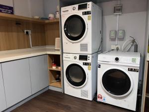 two washing machines and a washer and dryer in a kitchen at Q Inn by Pillow Plus in Petaling Jaya