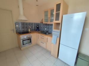 a small kitchen with a stove and a refrigerator at La petite Amandaise in Saint-Amand-sur-Sèvre +2 photos