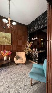 a living room with a couch and a chair at Hotel y Hostal AH MUN in Mérida +1 photo