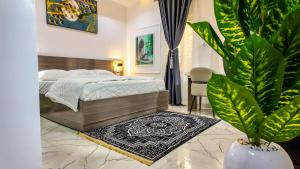 a bedroom with a bed and a potted plant at Jayhaven Crystal Serviced Apartment in Uyo