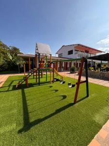 a playground with swings on a green lawn at Hotel Campestre Alma Nativa in Calarcá