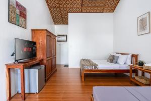 a living room with a bed and a tv at Badi's Place in Moalboal