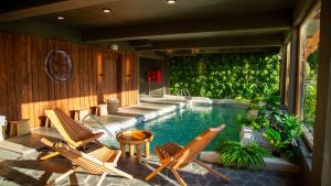 a swimming pool with two chairs and a table at Cascadas Hotel in Puerto Octay