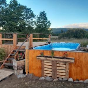a pool with a deck and a hot tub at Cabaña Bellavista in Manzanar