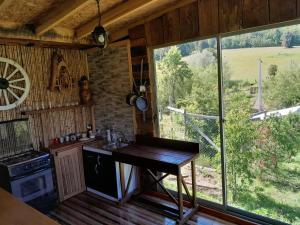 a kitchen with a table and a large window at Cabaña Bellavista in Manzanar