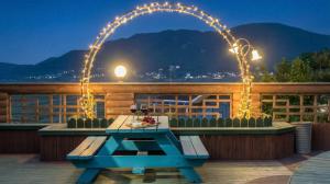 a picnic table on a deck at night with lights at Gangwha Jeongwon Pension in Incheon