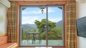 a room with a balcony with a table and chairs at Gangwha Jeongwon Pension in Incheon +1 photo