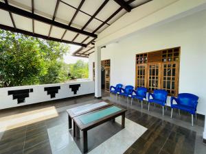 a living room with a table and blue chairs at Golden Palace Yala in Tissamaharama