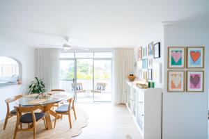 a kitchen and dining room with a table and chairs at The Chelsea Beachside Apartment in The Entrance