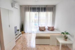 a bedroom with a bed and a large window at CBN Apartments in Lloret de Mar