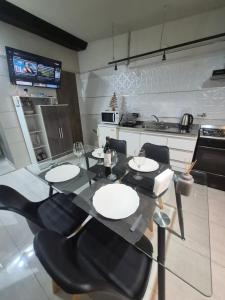 a kitchen with a glass table and black chairs at Pardo Mza in Godoy Cruz