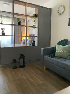 a living room with a couch and a clock on the wall at Rosario SJ Loft Studio in Rosario +24 photos