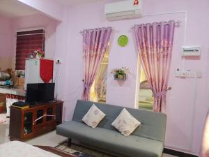 a living room with a couch and a tv at Dan's Homestay Bangau in Temerloh