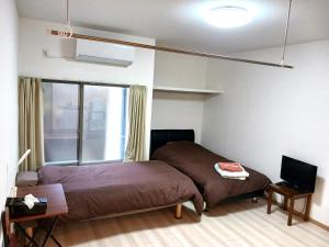 a bedroom with a bed and a television in it at 別館JOUNi in Niijimamura