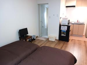 a living room with a bed and a kitchen at 別館JOUNi in Niijimamura