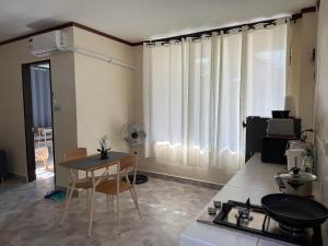 ein Wohnzimmer mit einem Tisch und einer Küche in der Unterkunft Phines Place in Panglao + 26 Fotos