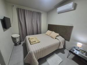 a small bedroom with a bed and a air conditioner at Pardo Mza in Godoy Cruz