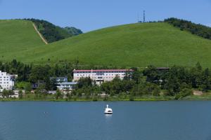 a small boat in the middle of a lake at Shirakabako Hotel Paipuno Kemuri in Chino