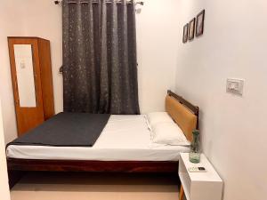 a small bed in a room with a curtain at Vibes stay in 3 in Hyderabad