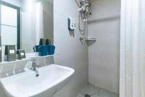 a white bathroom with a sink and a shower at Luna Hotel Pasay in Manila +27 photos