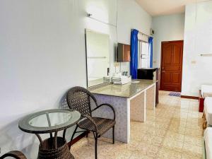 a living room with a table and chairs in a room at Chumphon Park Resort in Chumphon