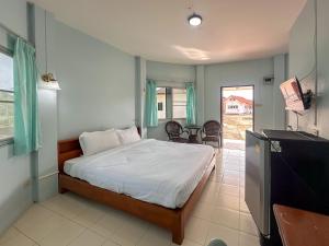 a bedroom with a bed and a television and a table at Chumphon Park Resort in Chumphon