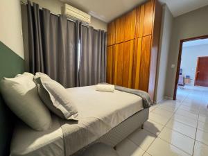 a bedroom with a bed with white pillows and a window at Complete and well located stay! in Barreiras