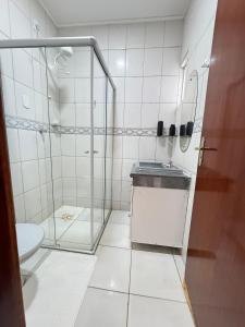 a bathroom with a glass shower and a toilet at Complete and well located stay! in Barreiras