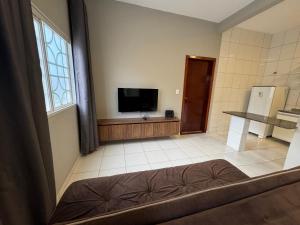 a room with a flat screen tv and a kitchen at Complete and well located stay! in Barreiras